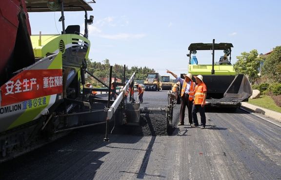 攤鋪機(jī)、壓路機(jī)等設(shè)備緊張有序運(yùn)行，高達(dá)170℃的瀝青混合料炙烤著公路人